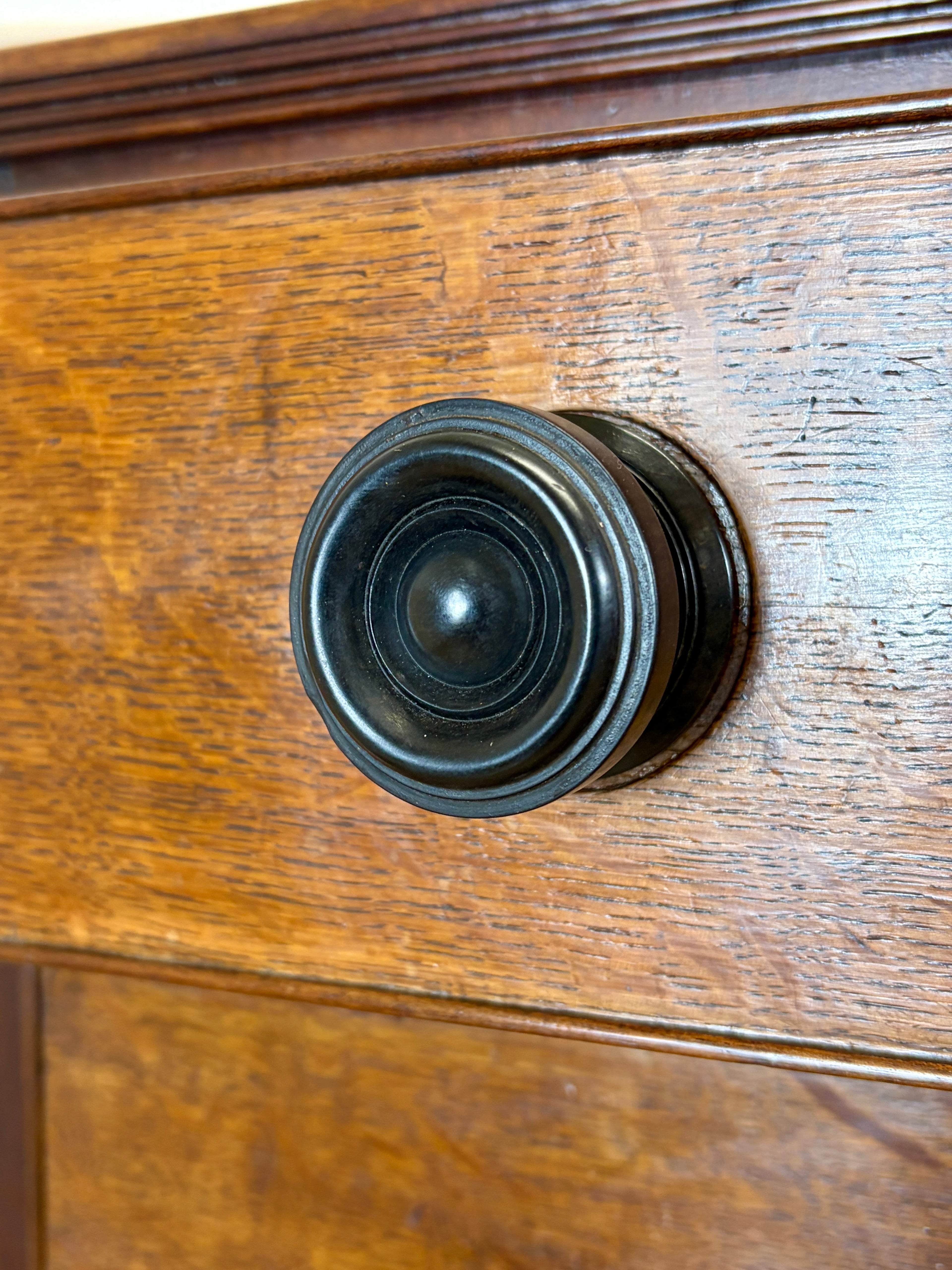 Close-up of a wooden drawer with a black metal knob