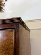 Close-up of a wooden cabinet corner with a neutral background