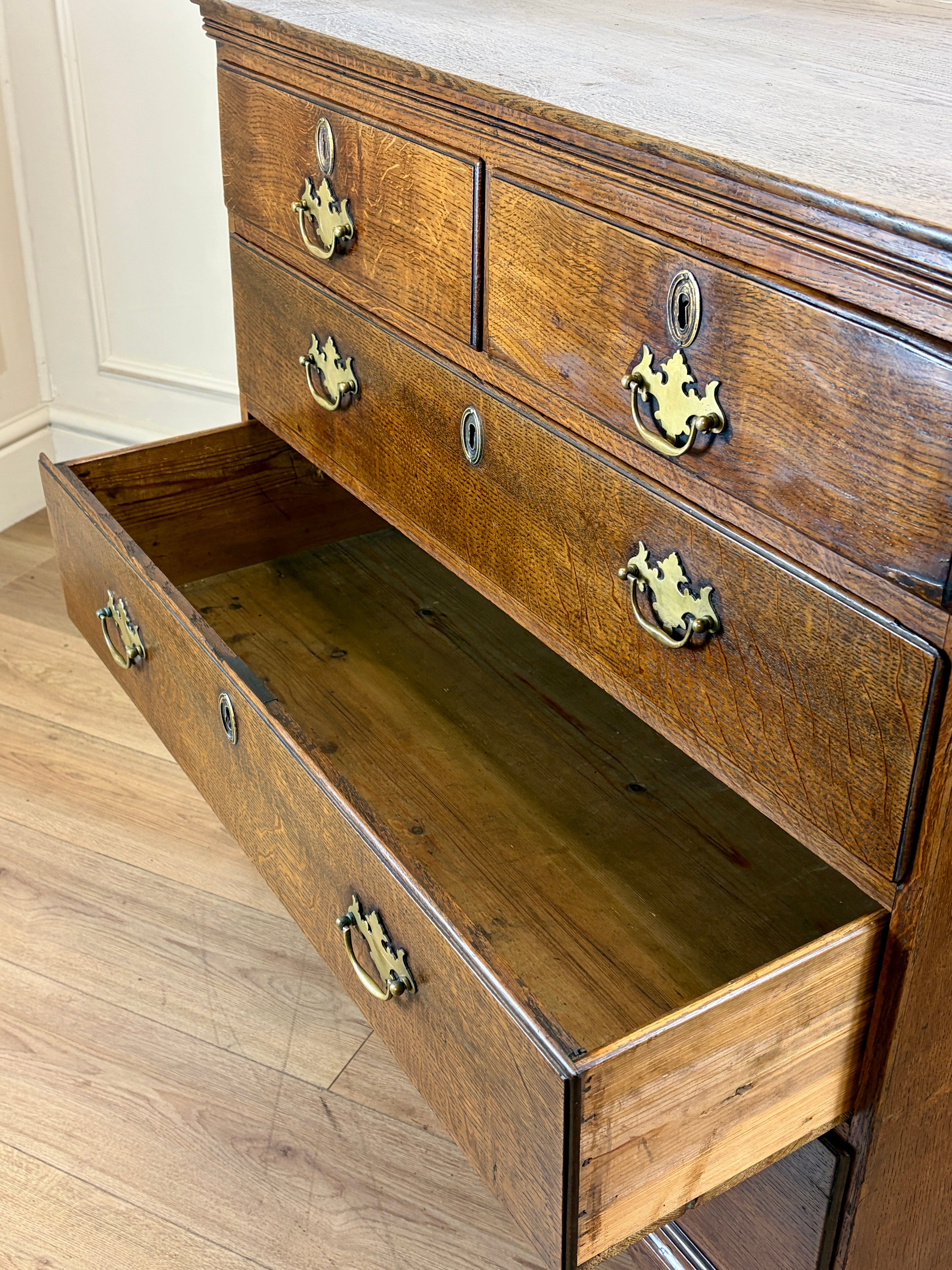 Antique light oak farmhouse chest of drawers with brass handles and patina