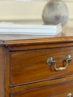 Close-up of a wooden drawer with a brass handle, blurred background