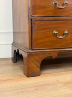 Wooden dresser with two drawers on a wooden floor.