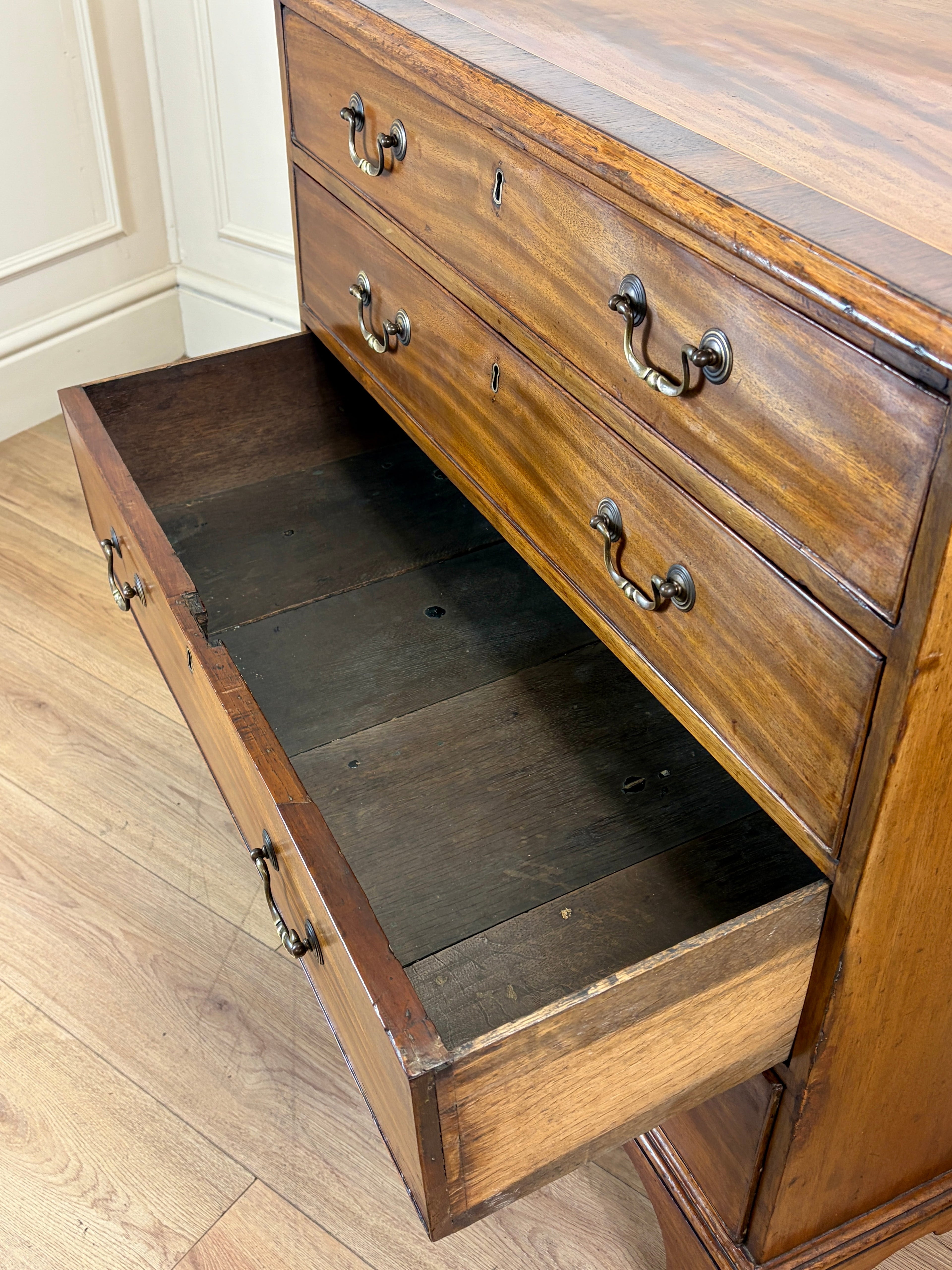Wooden dresser with open drawer on a wooden floor