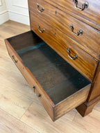 Wooden dresser with an open drawer on a wooden floor