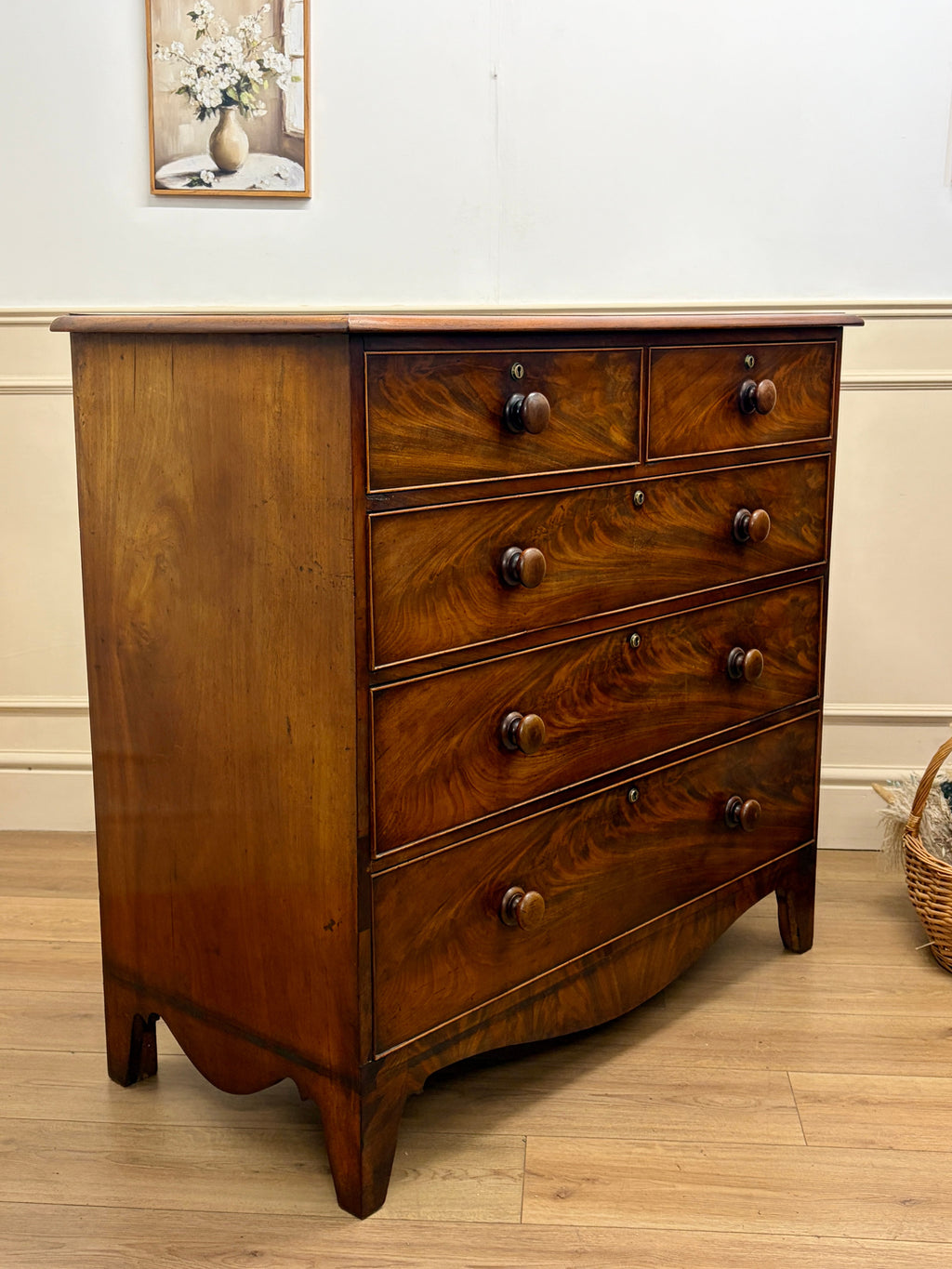 Wooden dresser with four drawers on a wooden floor.