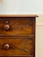 Wooden drawer with two knobs on a plain background