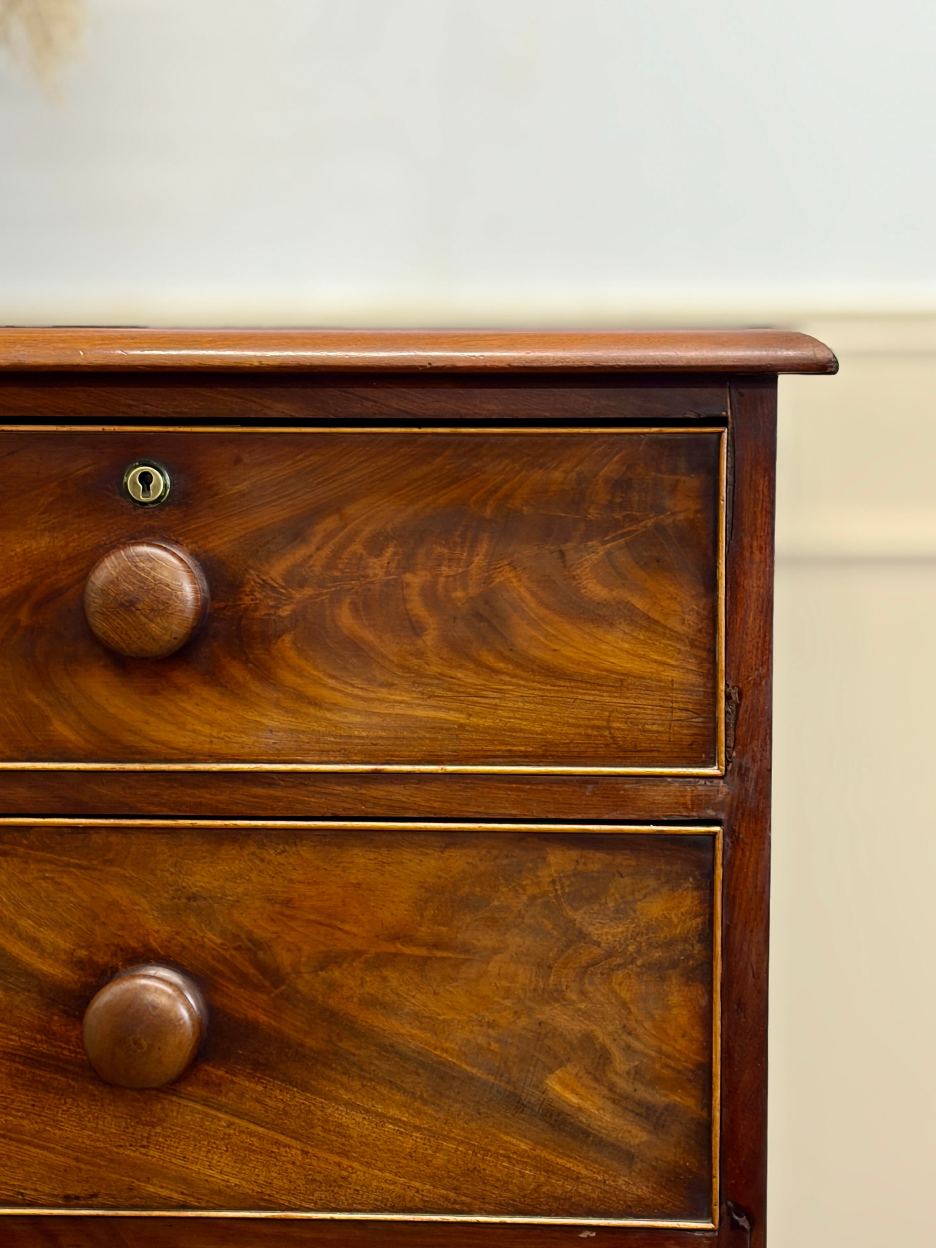 Wooden drawer with two knobs on a plain background