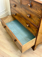 Wooden dresser with open drawer on a wooden floor