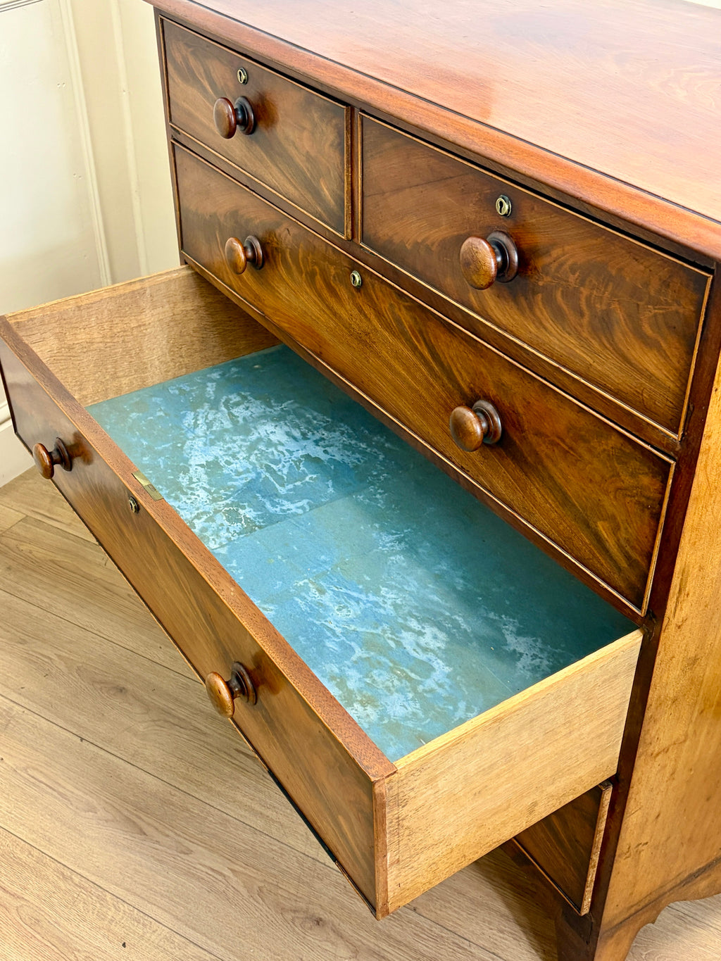 Wooden dresser with an open drawer revealing a blue interior.
