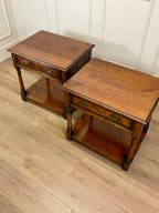 Two wooden side tables on a wooden floor with a white paneled wall in the background.
