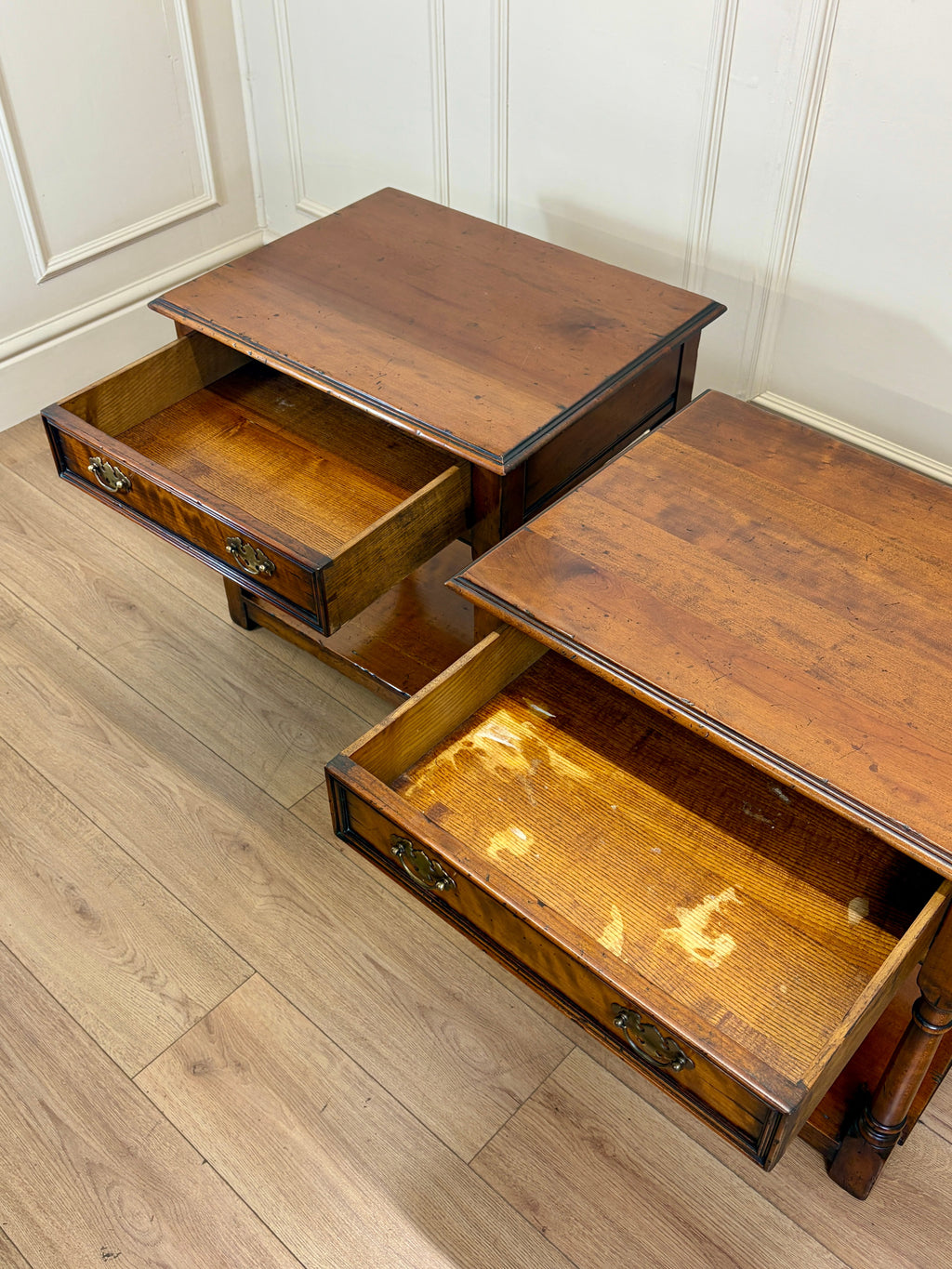 Two wooden step stools with drawers on a wooden floor.