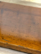 Close-up of a worn wooden surface with visible scratches and scuffs.