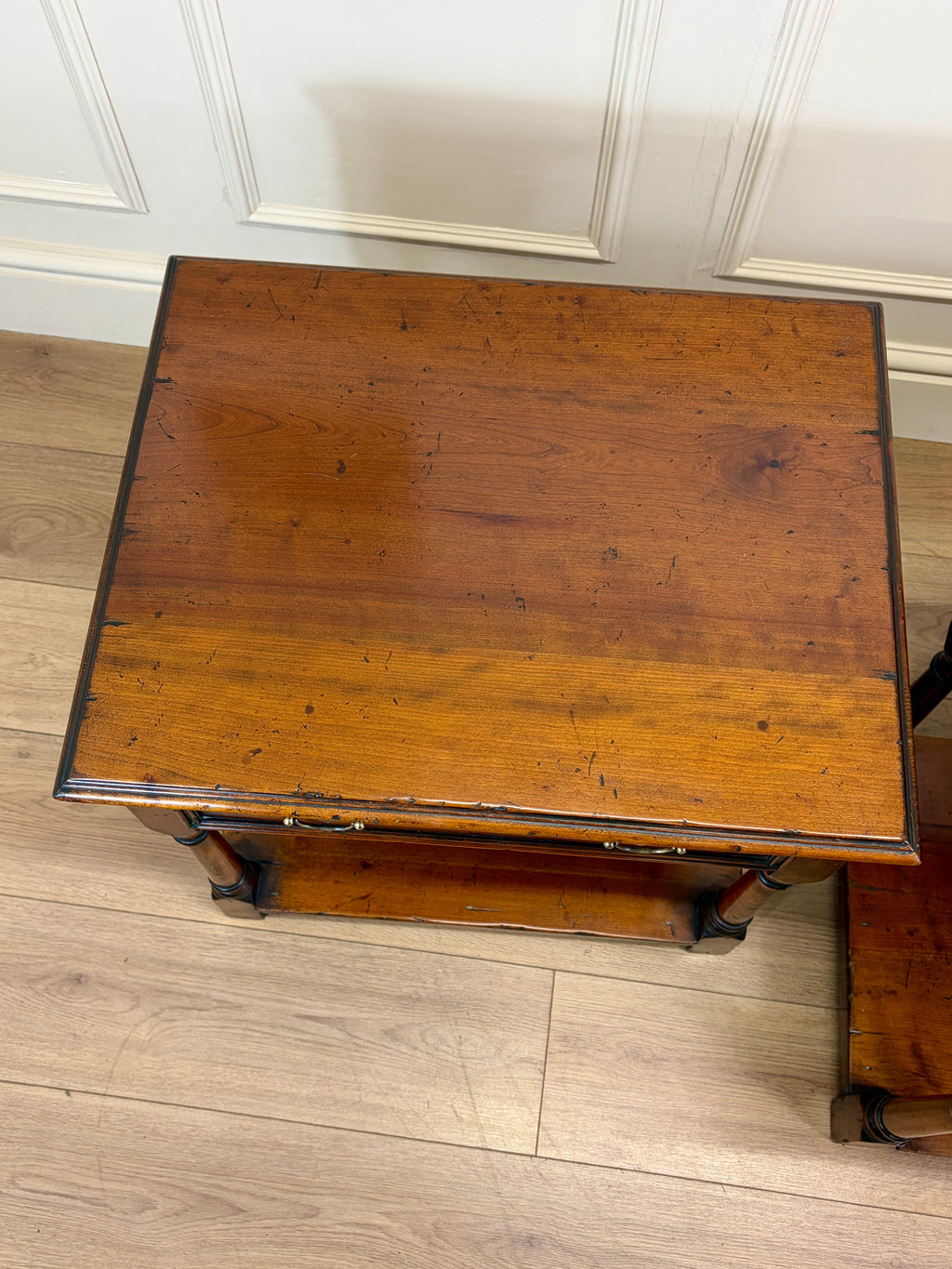 Wooden table with a worn surface on a wooden floor.