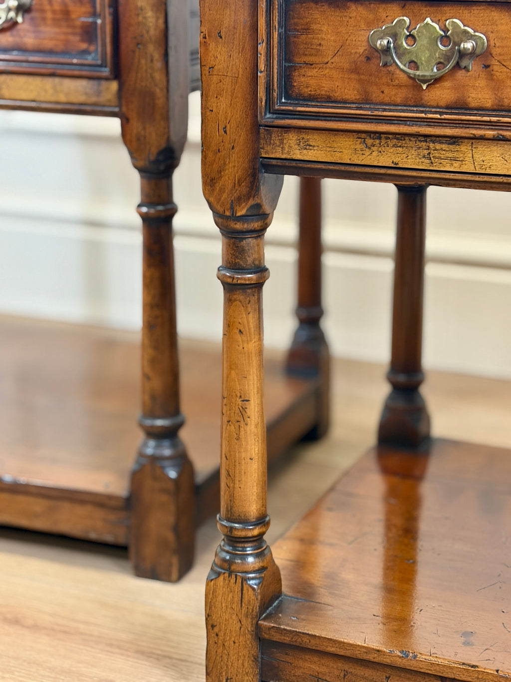 Close-up of a wooden side table with a drawer and metal handle.