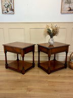 Two wooden side tables with a vase of flowers on a wooden floor.