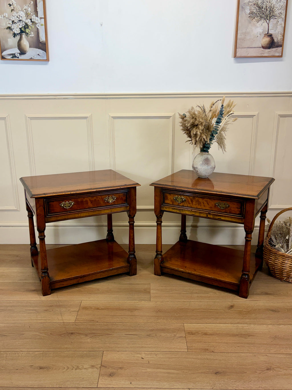 Two wooden side tables with a vase of flowers on a wooden floor.