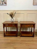 Two wooden side tables with a vase of flowers on a light wood floor.