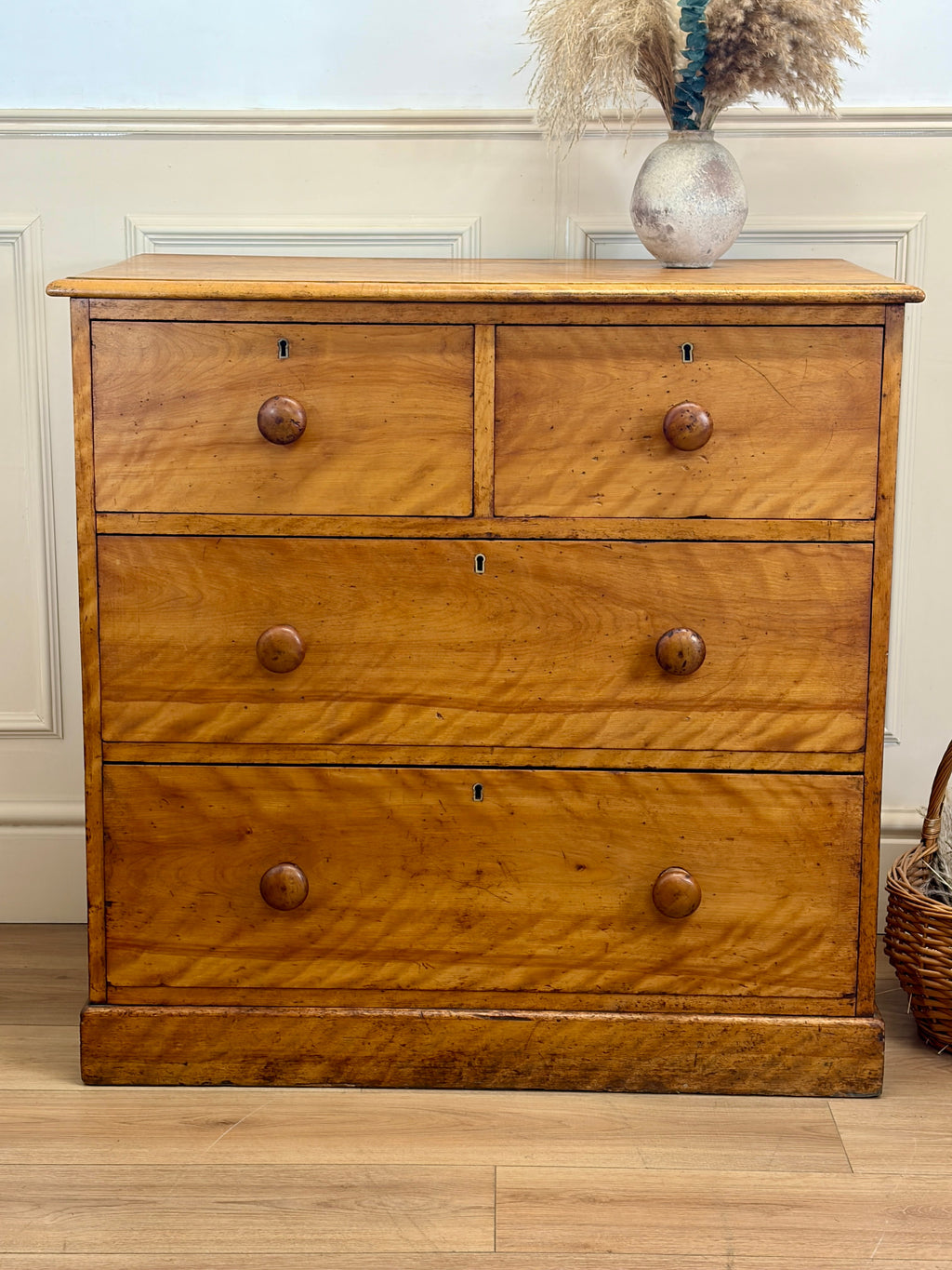 Wooden dresser with four drawers in a room setting