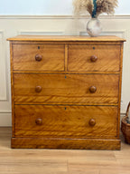 Wooden dresser with four drawers in a room setting
