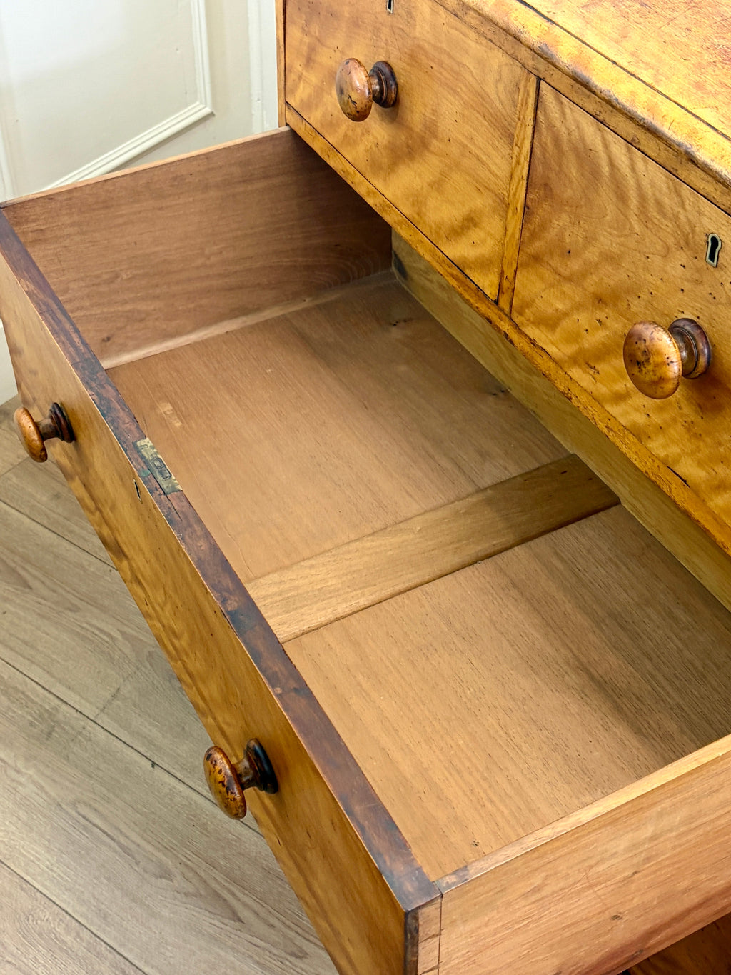 Wooden drawer with open lid on a wooden floor