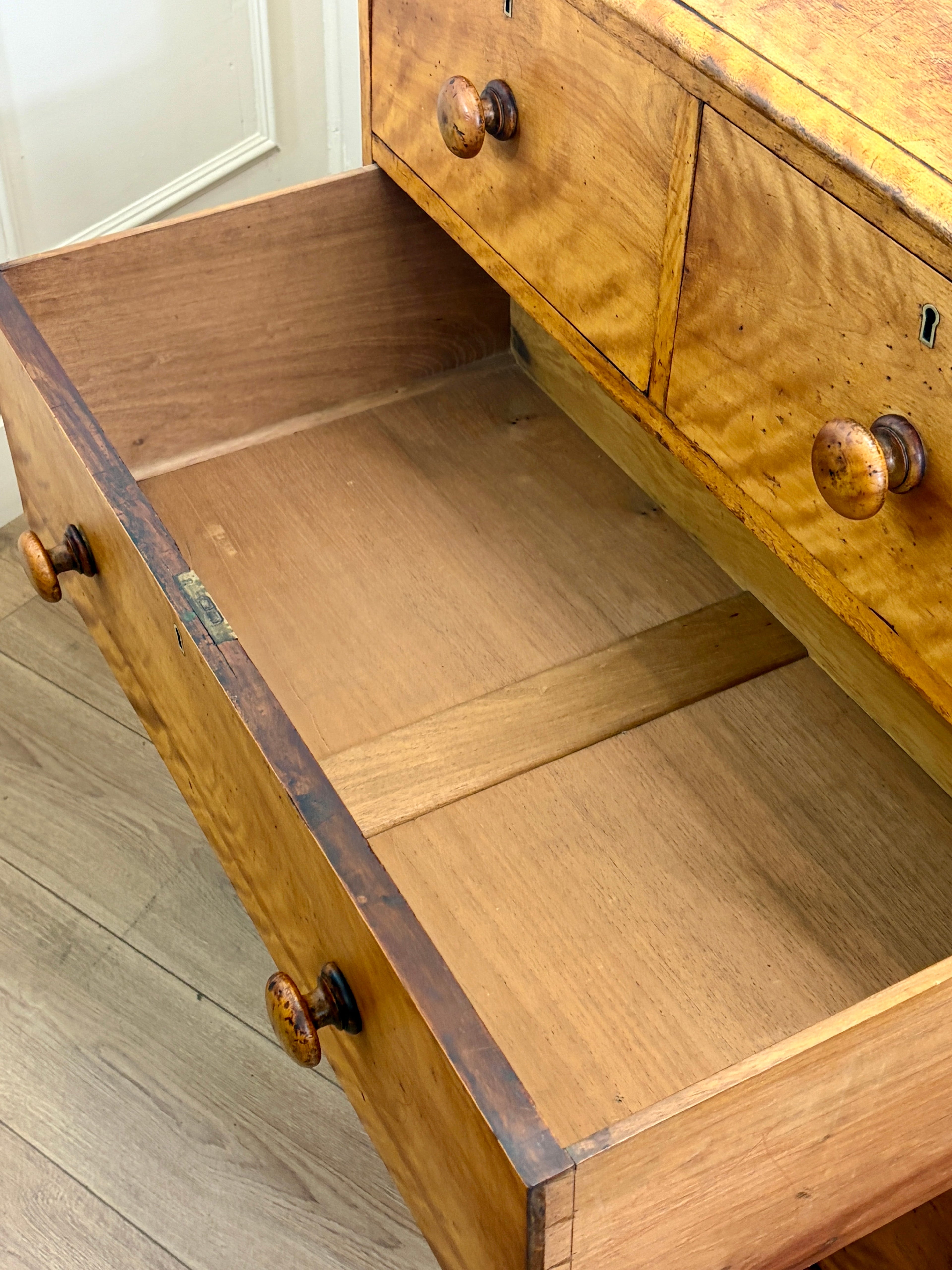 Wooden drawer with open lid on a wooden floor