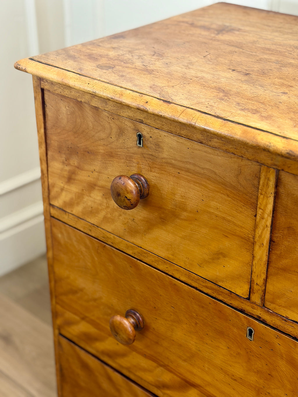 Wooden dresser with two drawers and a knob on a white wall background