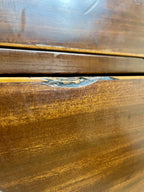 Close-up of a wooden surface with visible grain and a small scratch.