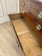 Wooden dresser with open drawer revealing wooden floor.
