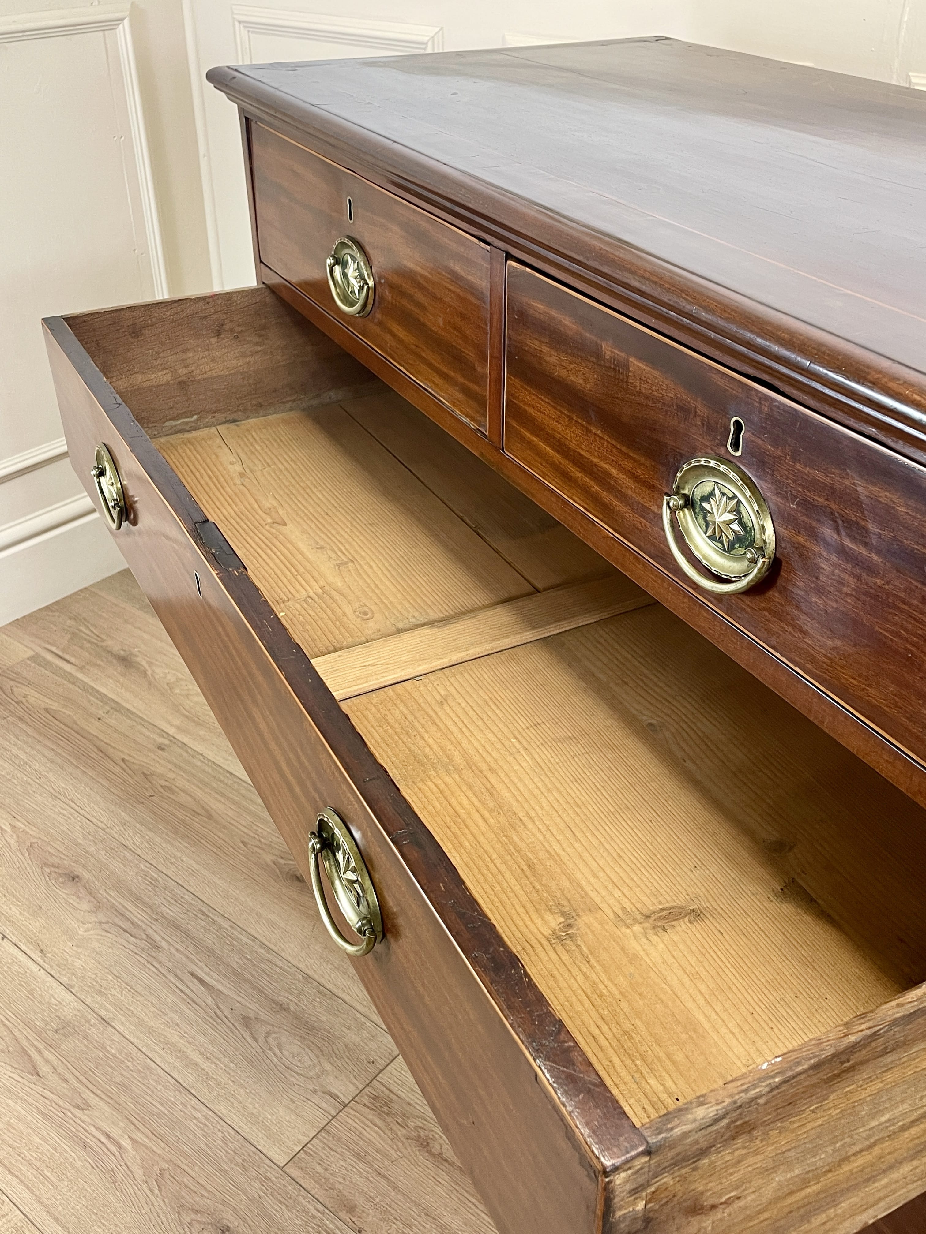 Wooden dresser with open drawer on a wooden floor