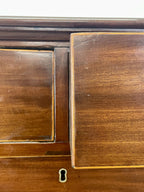 Close-up of a wooden cabinet with a keyhole on a white background