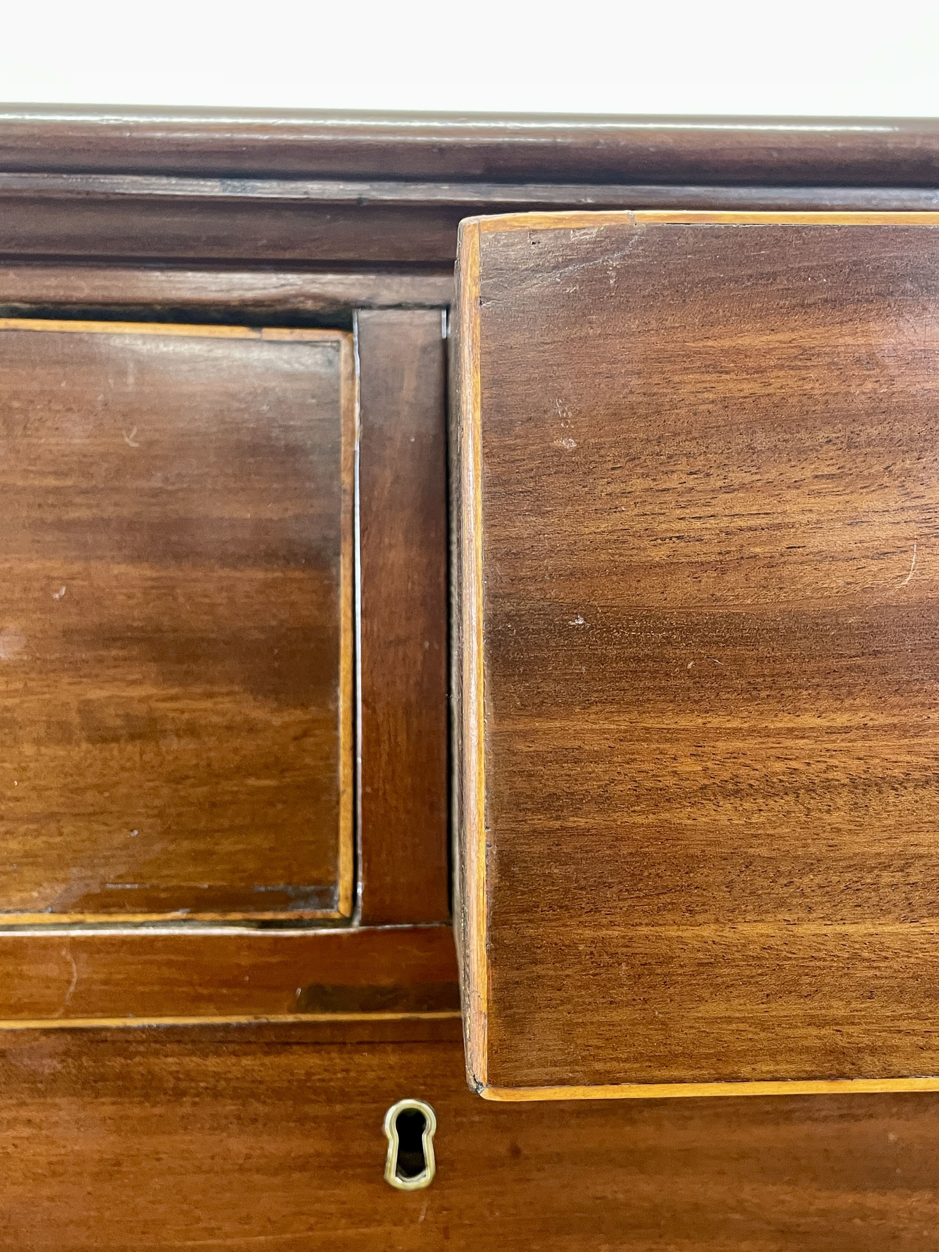 Close-up of a wooden cabinet with a keyhole on a white background