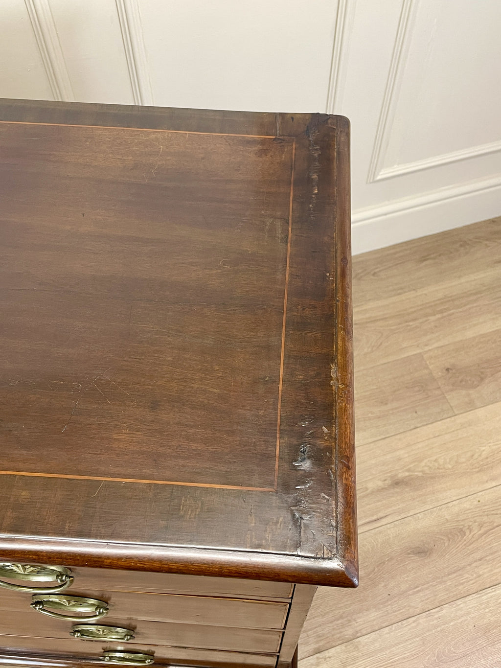 Wooden desk corner with a white paneled wall background