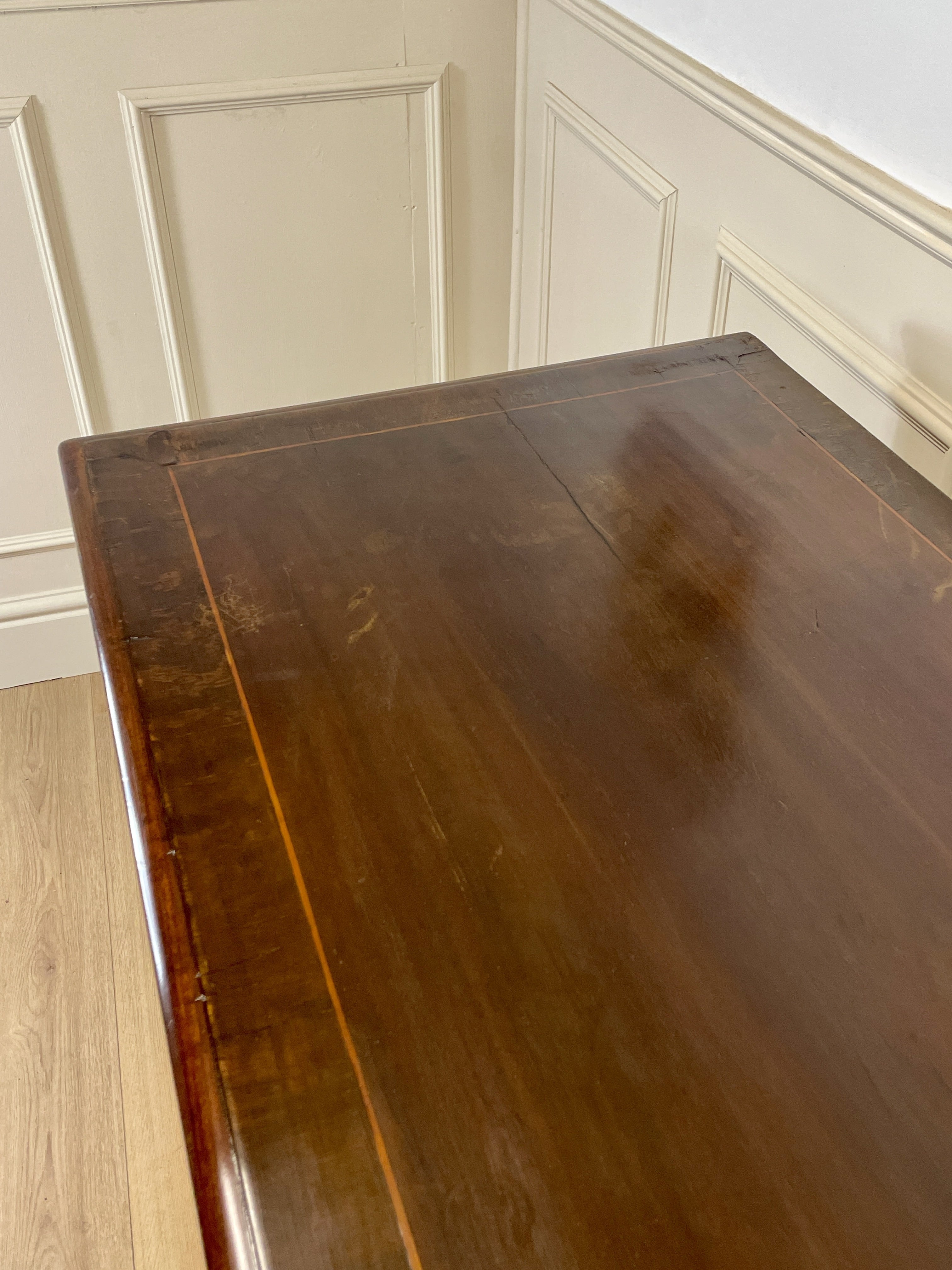 Wooden chest against a white paneled wall