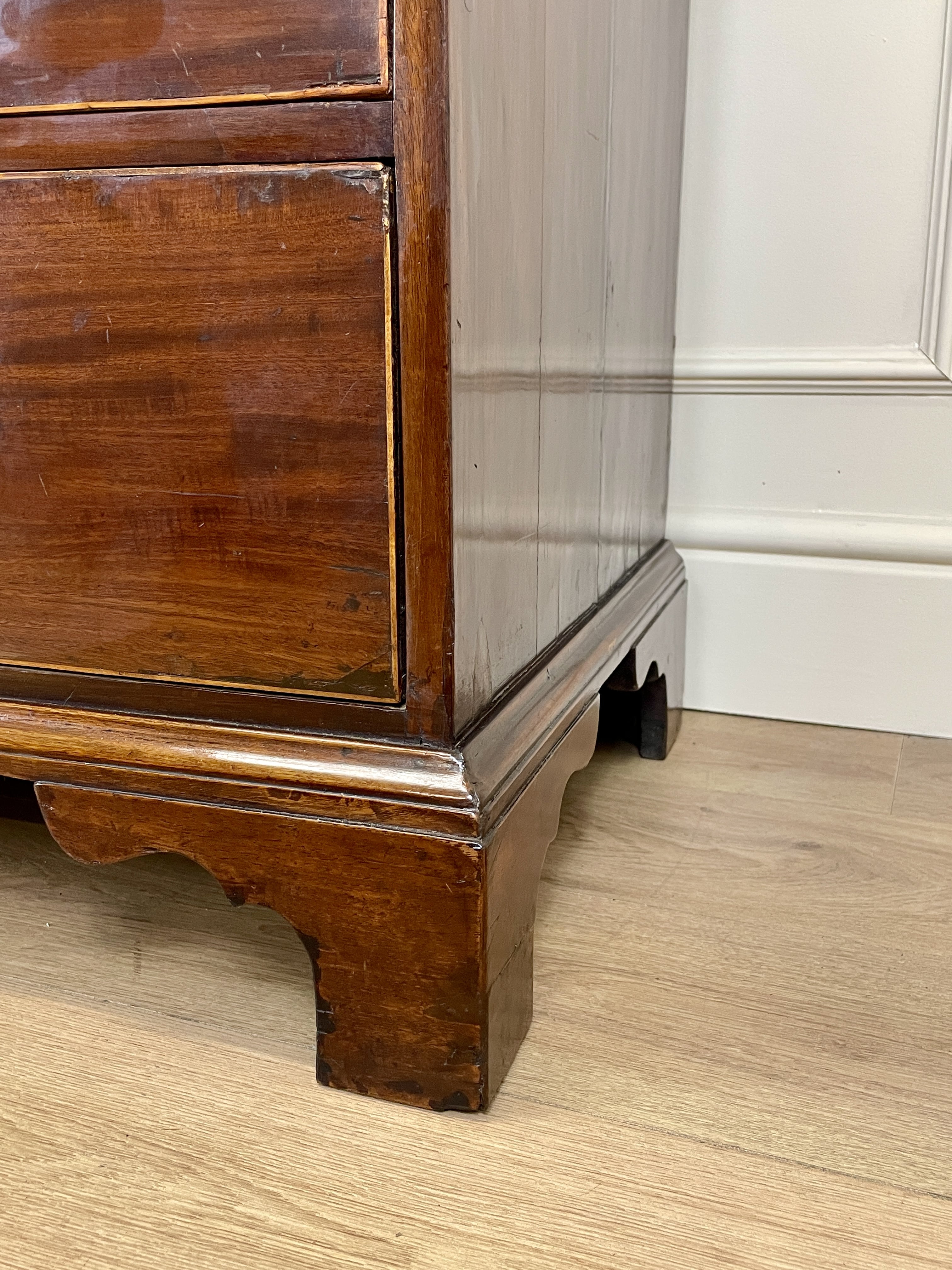 Wooden cabinet corner with a white wall background