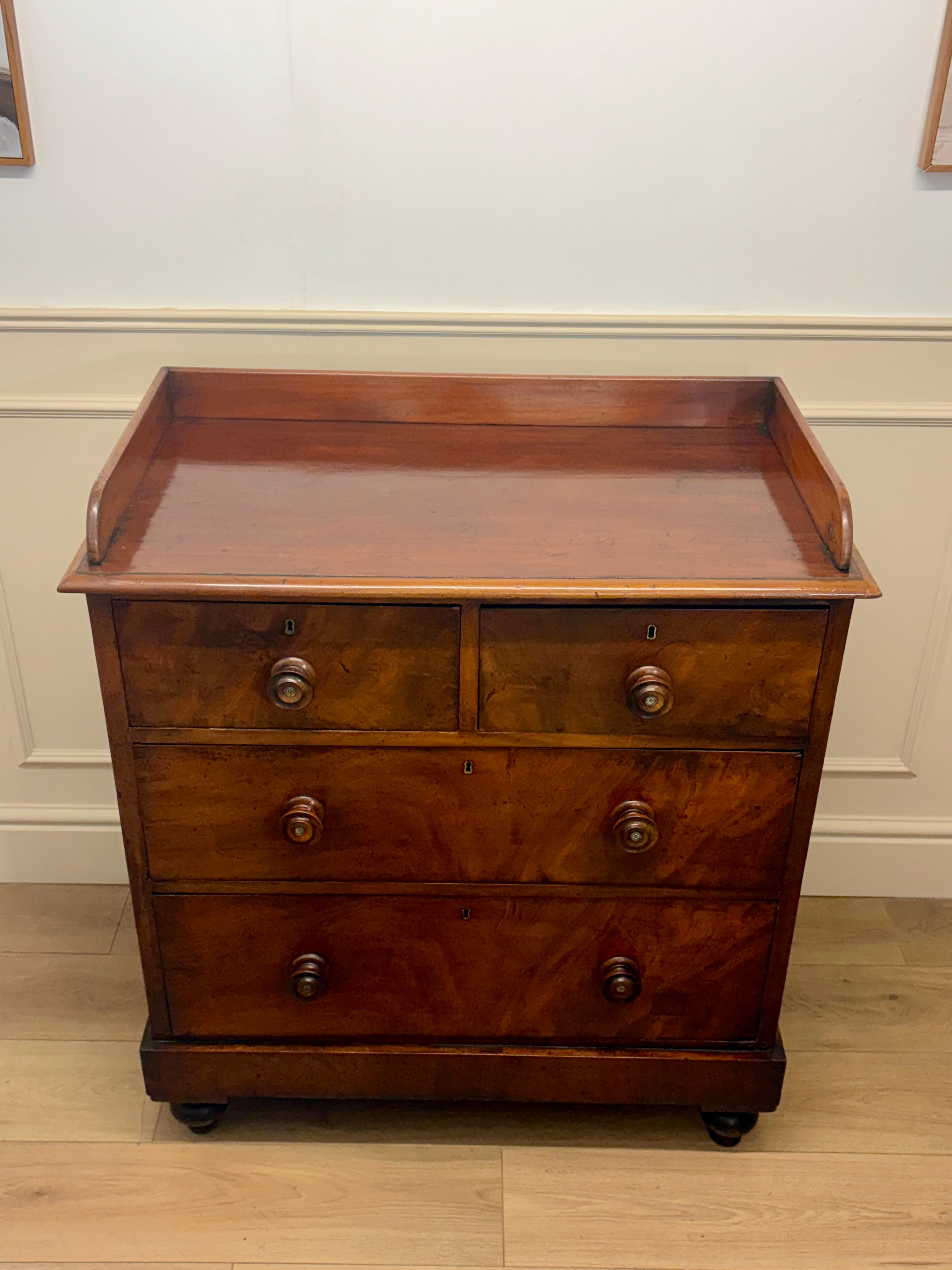 Wooden dresser with three drawers on a wooden floor against a white wall.