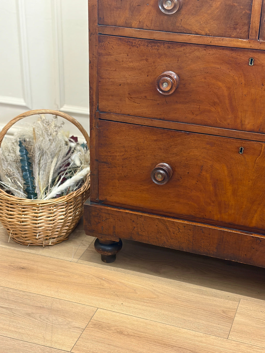 Wooden dresser with wicker basket on a wooden floor