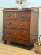 Wooden dresser with three drawers on a wooden floor.