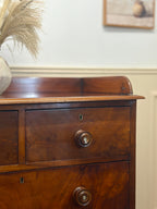 Wooden dresser with two drawers and a mirror in the background