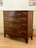 Wooden dresser with four drawers on a wooden floor.