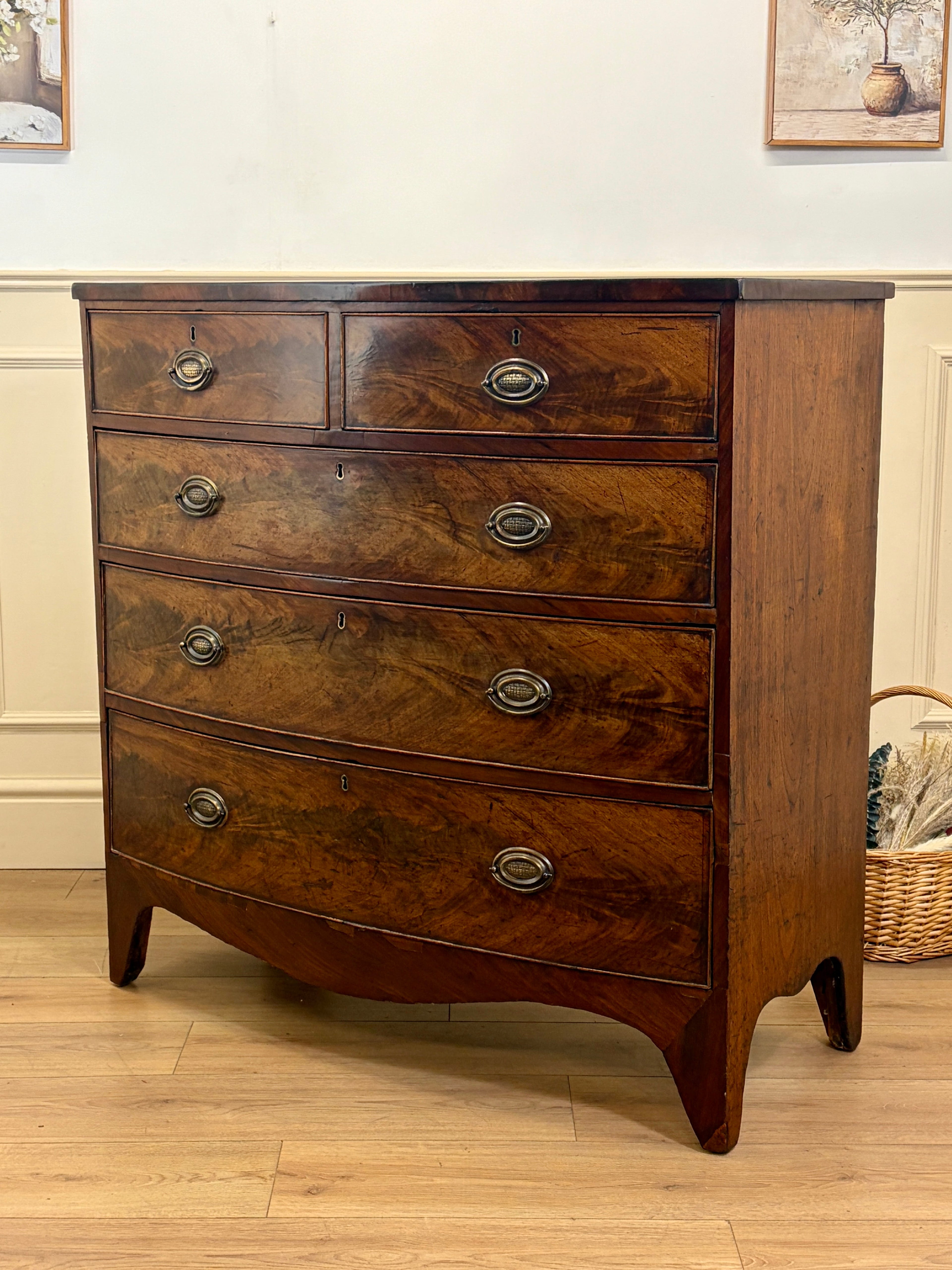 Wooden dresser with four drawers on a wooden floor.
