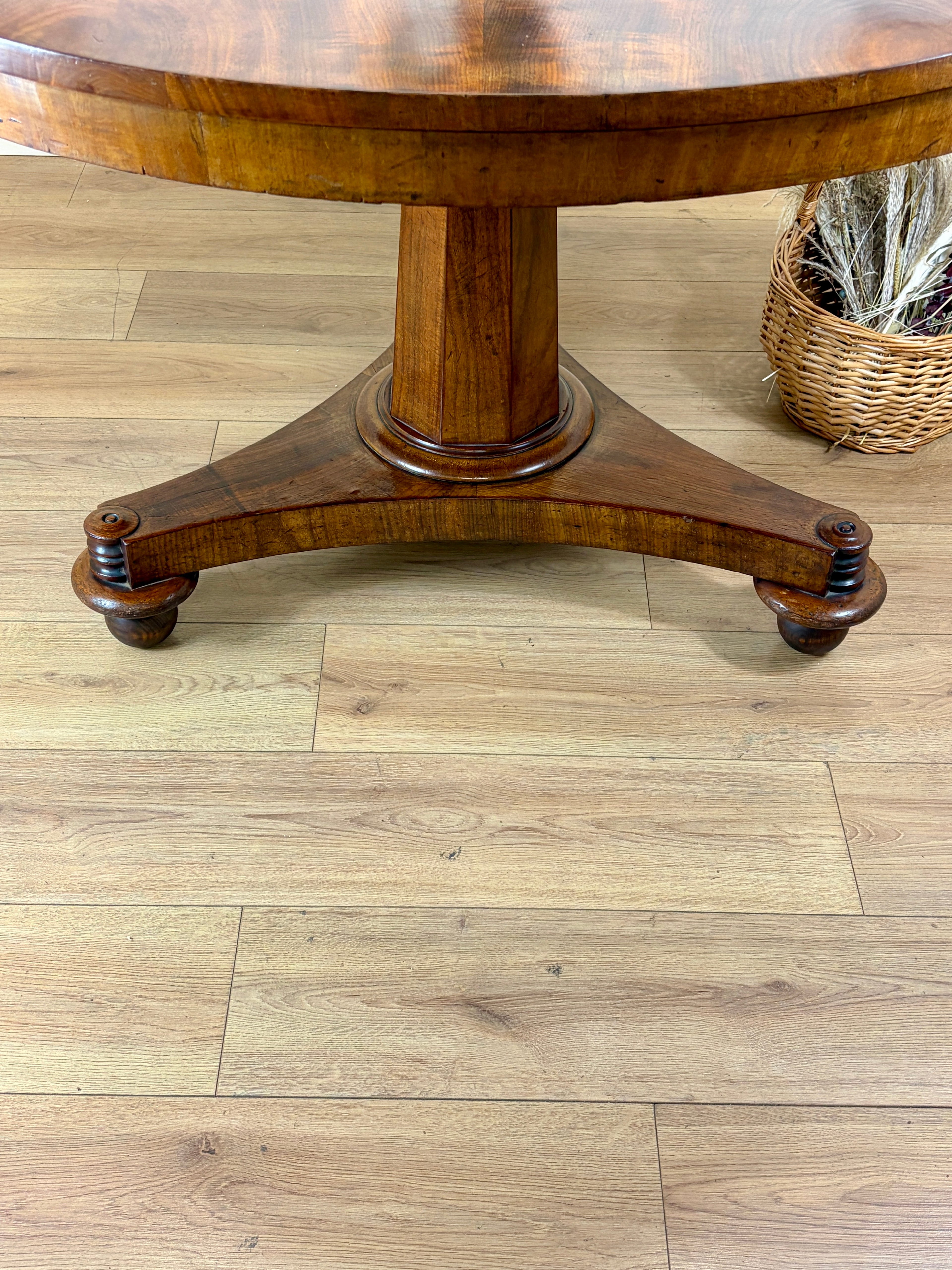 Wooden table on a wooden floor with a wicker basket in the background