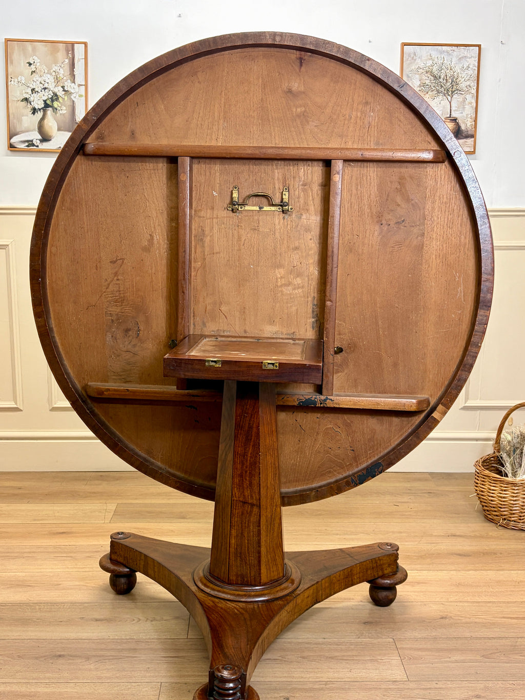 Wooden circular table with a cabinet on a wooden floor