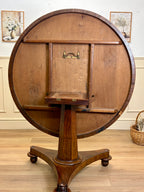Wooden circular table with a cabinet on a wooden floor