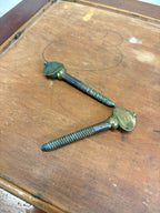 Two metal screws on a wooden surface