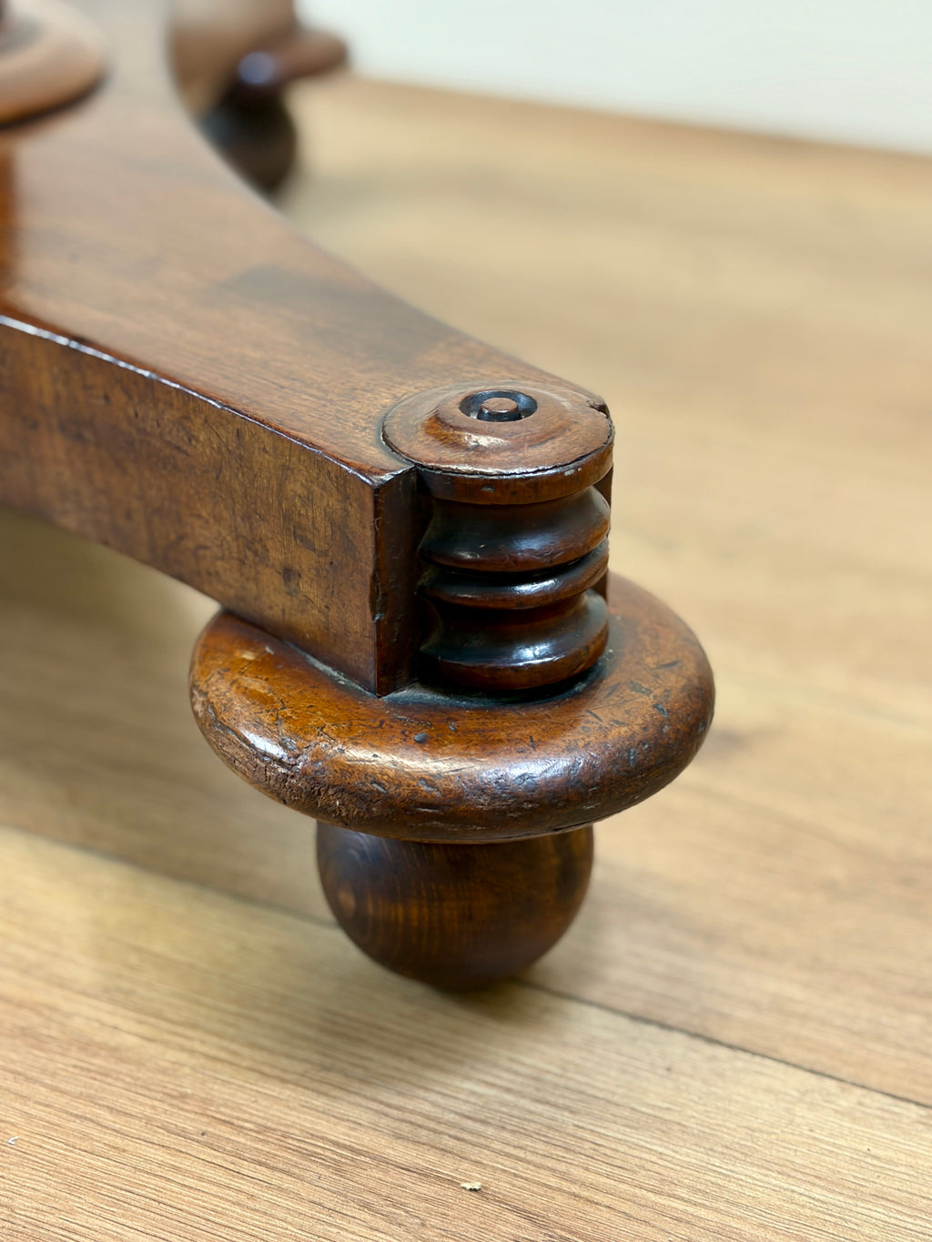 Wooden furniture leg with decorative turnings on a wooden surface