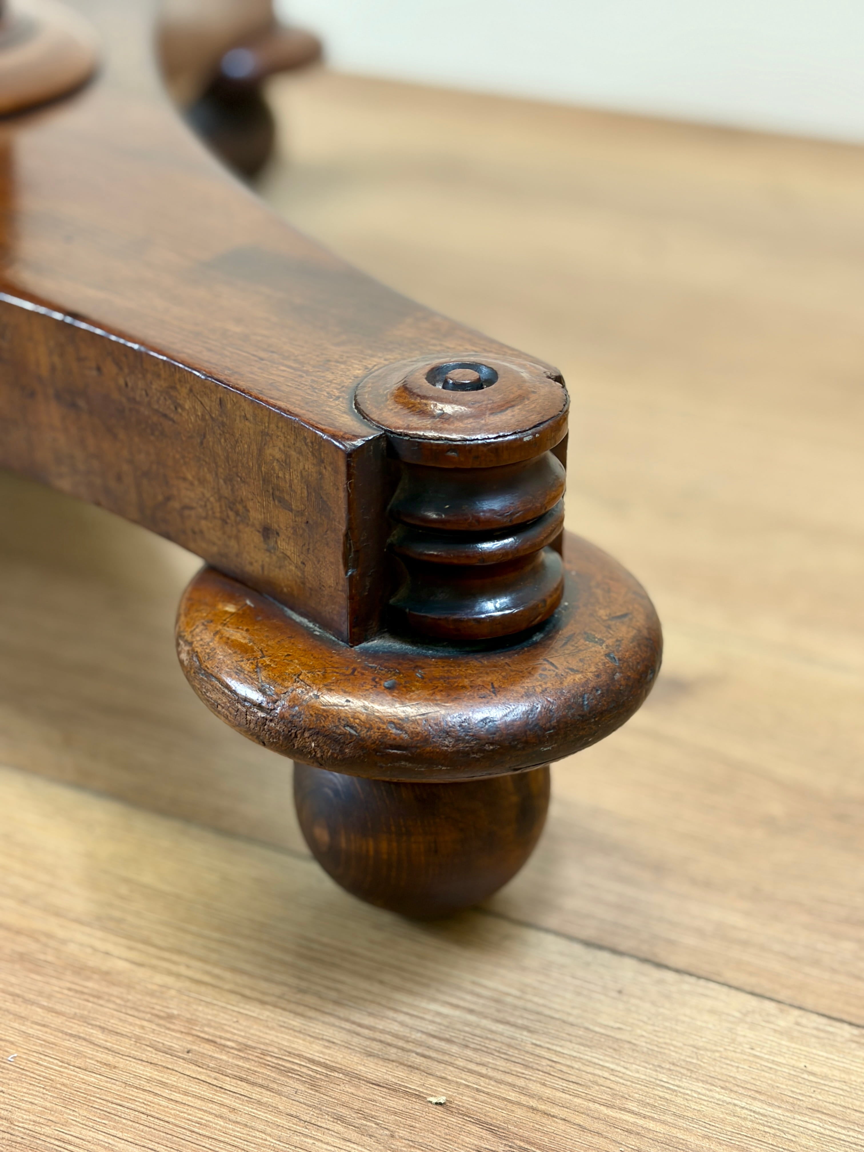 Wooden furniture leg with decorative turnings on a wooden surface