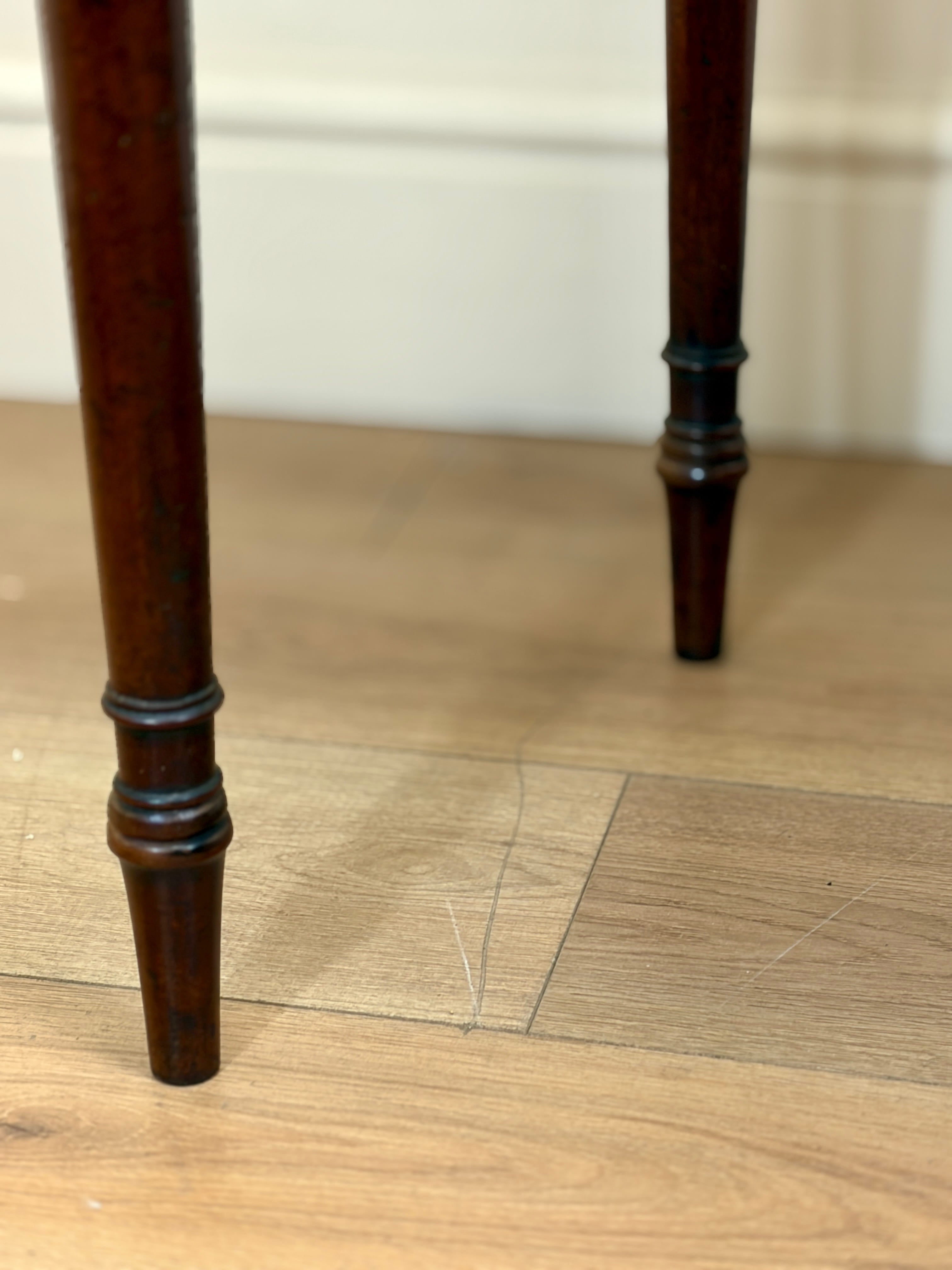 Close-up of wooden legs on a table with a light wood floor background