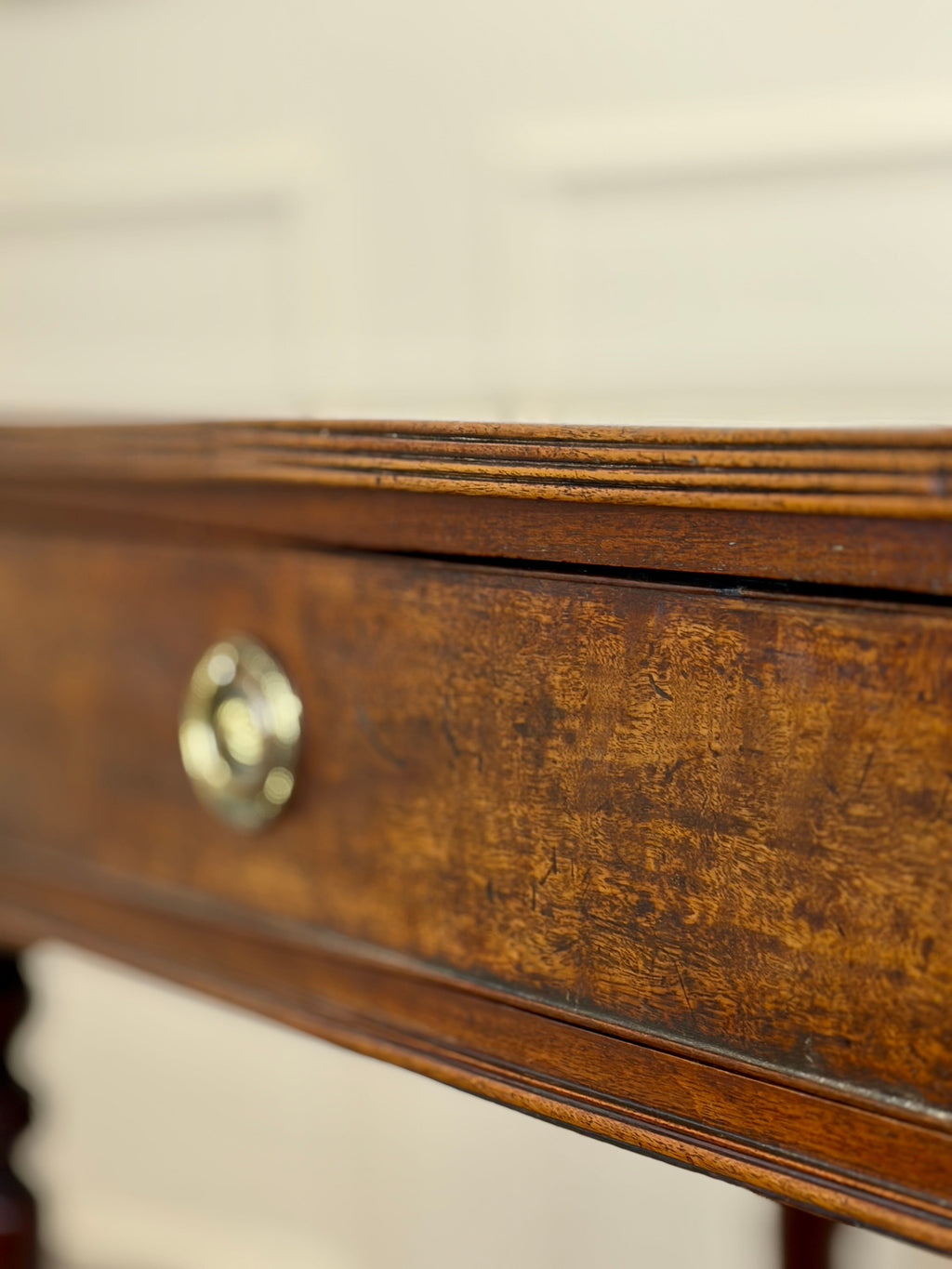 Close-up of a wooden drawer with a brass handle on a blurred background