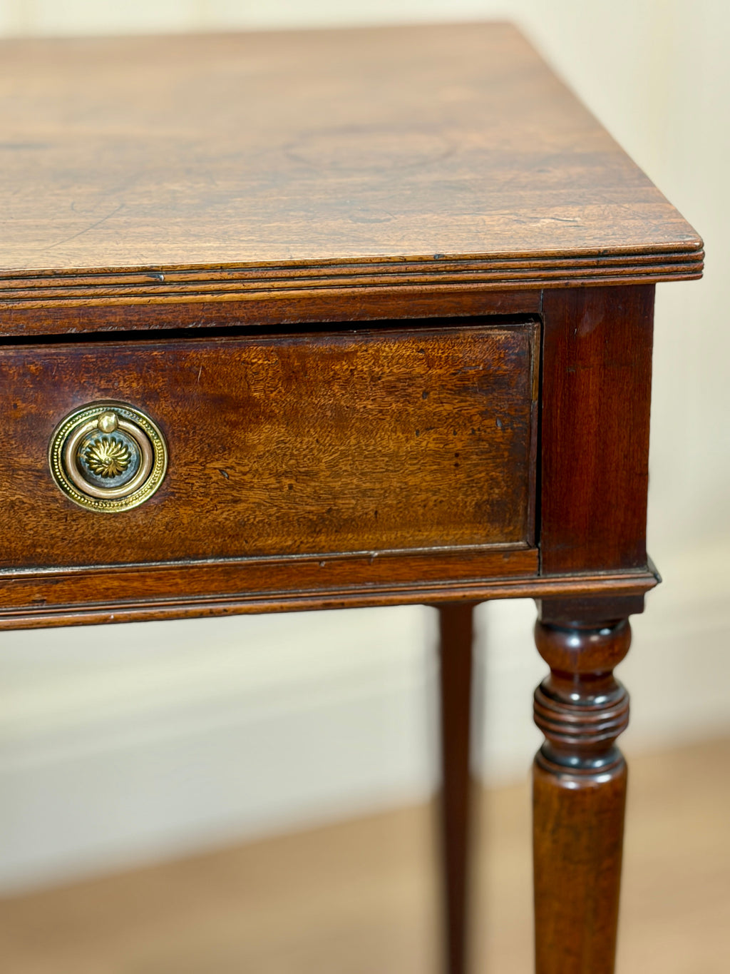 Wooden side table with a drawer and decorative knob on a plain background