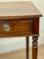 Wooden side table with a drawer and decorative knob on a plain background