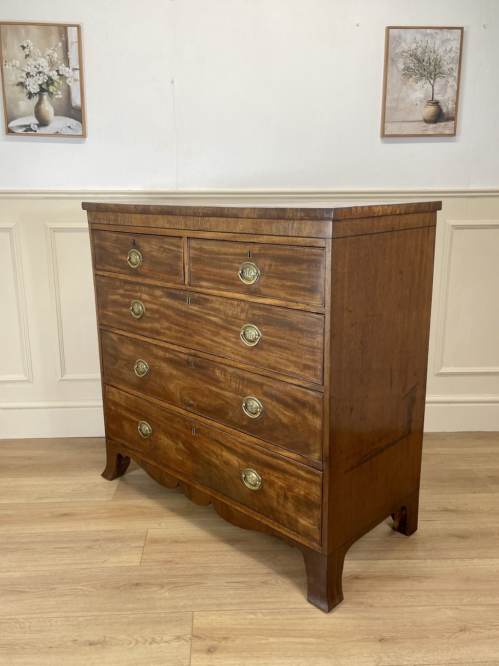 Angled view showing antique mahogany chest of drawers for bedroom with graduated drawers and Prince of Wales brasses